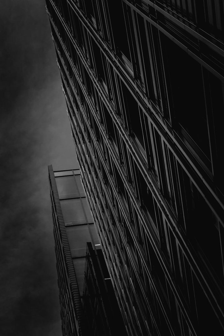 Black & white image taken from an unknown street location in London, UK. The style of the building facade reminds me of Gotham City when converted to B&W