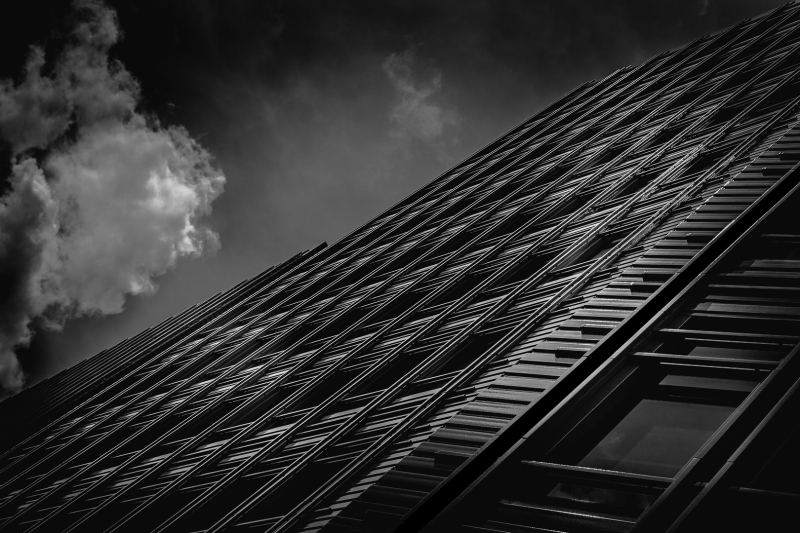 Black & white image taken from an unknown street location in London, UK. The black & white conversion of the steel building facade is a reminder of Gotham City